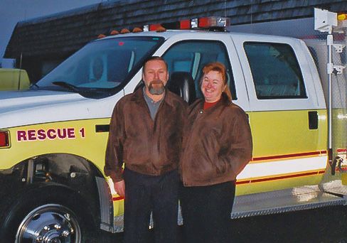 Founders Dave and Barb Hesse standing in front of Rescue 1 in 2005